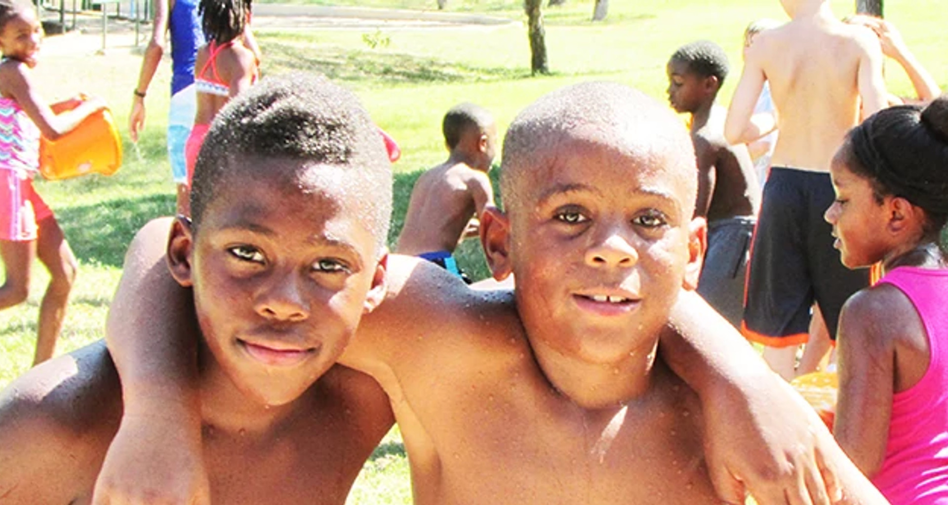 two boys posing for a photo while participating in a splash day